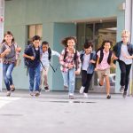 Group of elementary school kids running in a school corridor