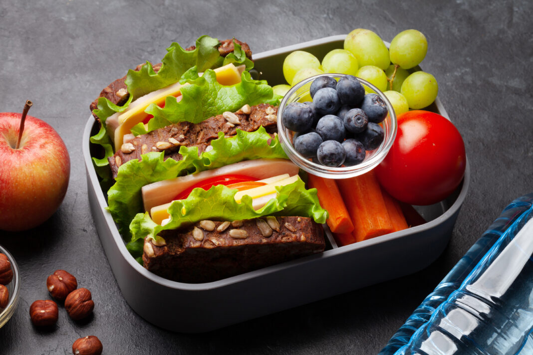 Healthy school lunch box with sandwich and fresh vegetables